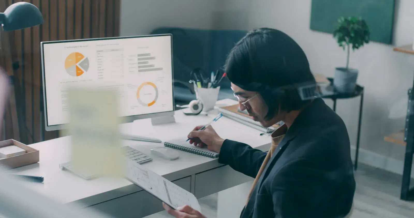 Business person reviewing analytics and charts at a modern office desk.